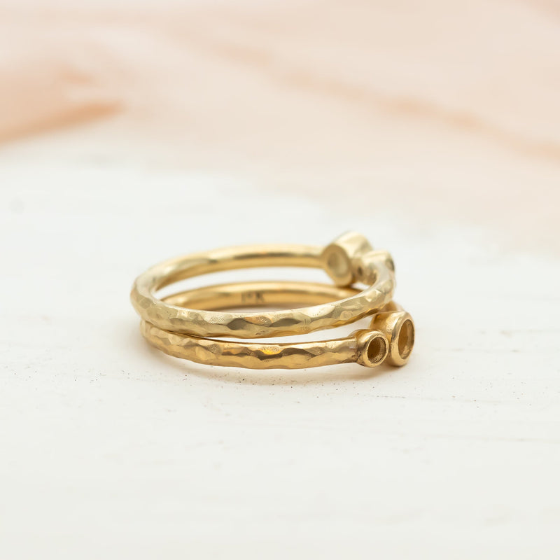 Stacked gold rings in different finishes, showing subtle differences in color and texture – illustrating the comparison between 14K and 18K gold.