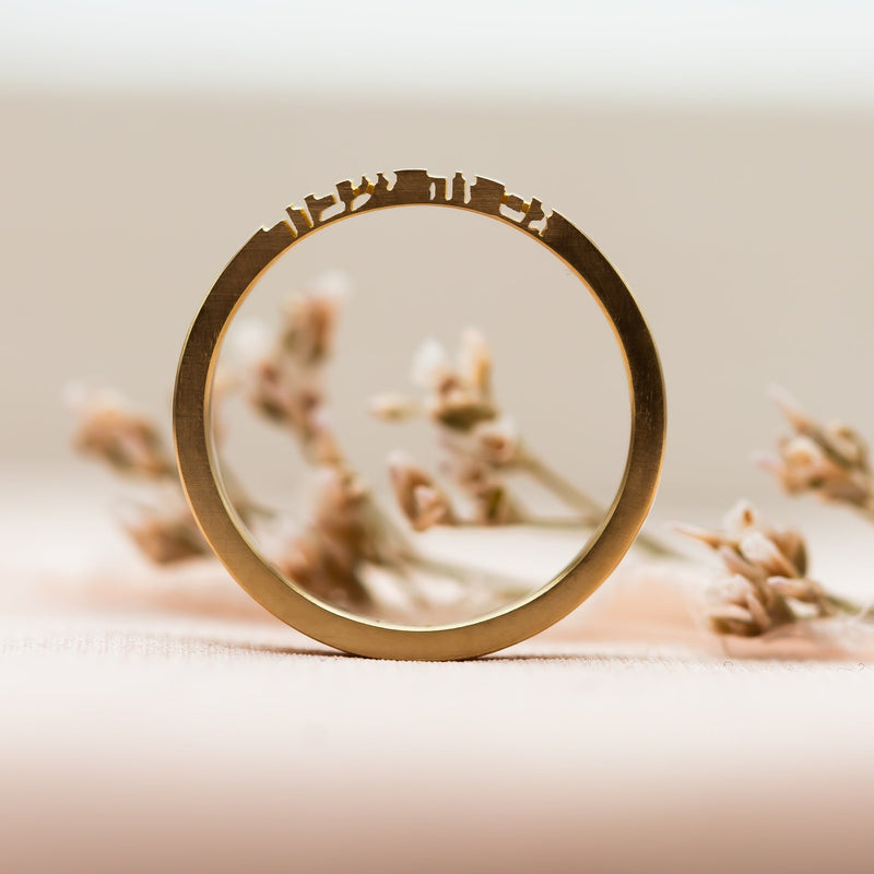 a minimalist gold ring engraved in Hebrew with the words "This too shall pass" - a symbolic design from the Whispers of Gold collection by Sivan Lotan.