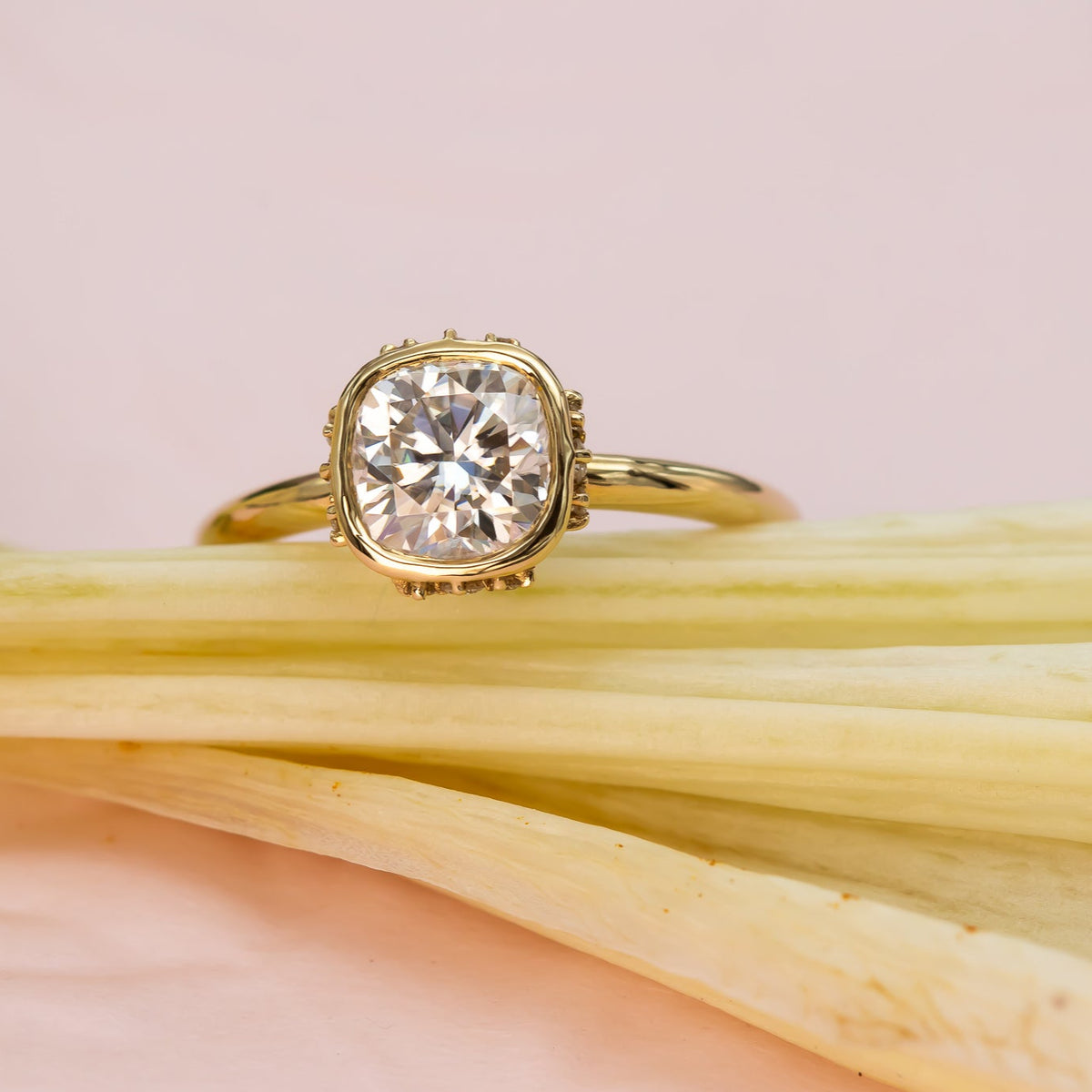 Elegant cushion-cut diamond ring in solid gold with sculpted bezel and side diamonds, handcrafted in a vintage-inspired modern design.