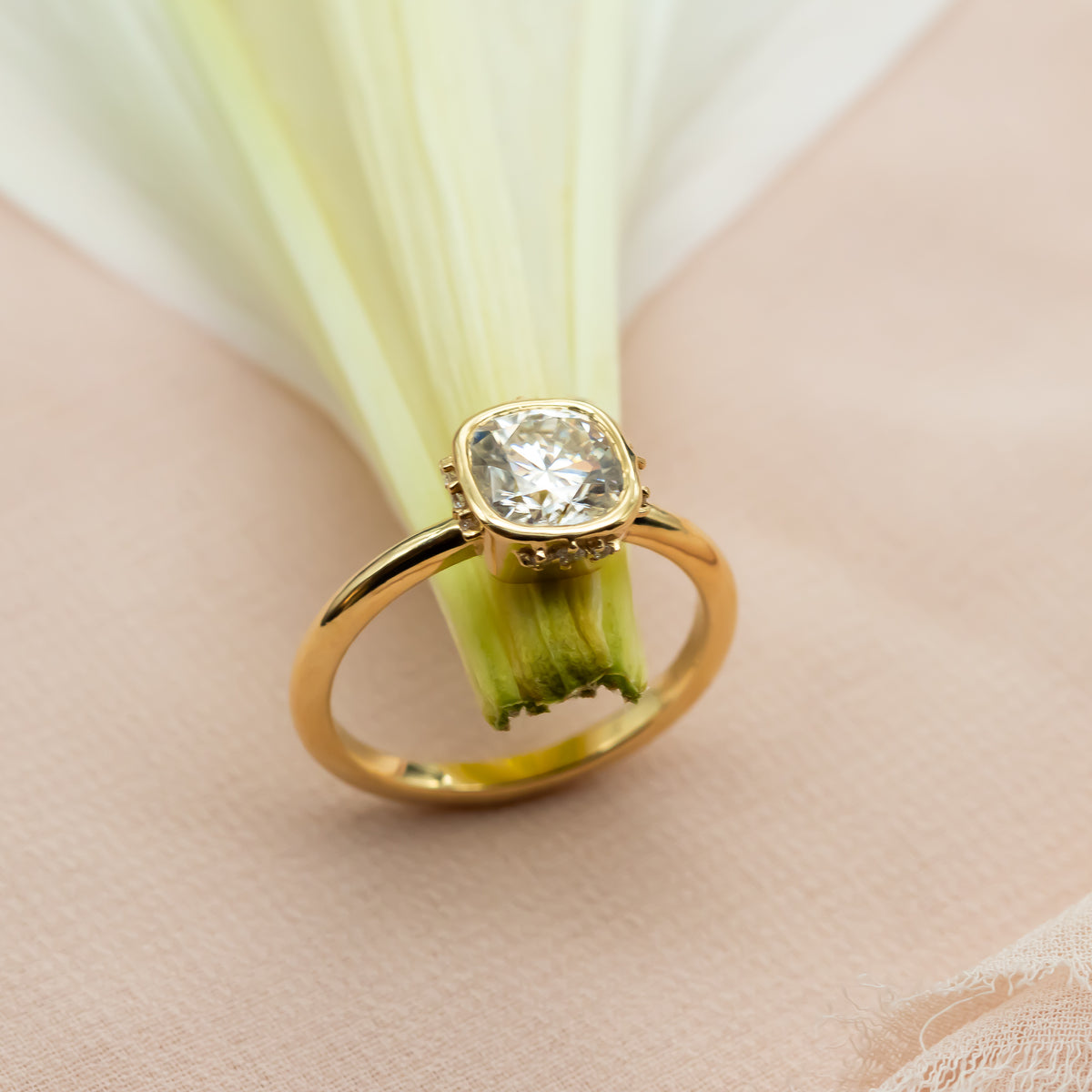 Elegant cushion-cut diamond ring in solid gold with sculpted bezel and side diamonds, handcrafted in a vintage-inspired modern design.