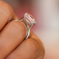 Side view of rose quartz ring with diamond-lined gallery raised on a tapered gold band