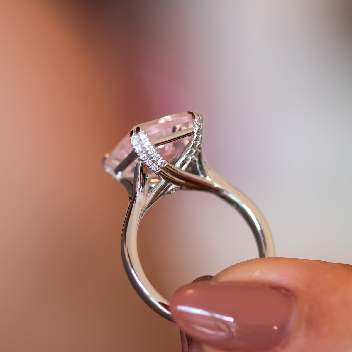 Side profile of the Verena rose quartz ring showing diamond-set shoulders and tapered gold band