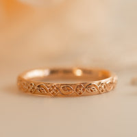 A photo of rose gold wedding band, thin gold ring, flower and leaves lace wedding band, floral gold wedding band in 14k gold