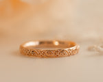A photo of rose gold wedding band, thin gold ring, flower and leaves lace wedding band, floral gold wedding band in 14k gold